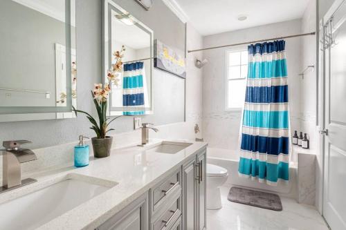 a bathroom with a sink and a toilet and a mirror at LUXURY 6000 sqft Mansion in Downtown Orlando Sleeps 12 in Orlando