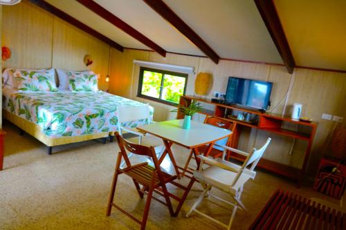 a bedroom with a bed and a table and chairs at Casa Congo & Casa Rayo Verde - Restaurante - Galeria de arte in Portobelo