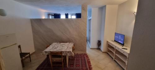 a room with a table and a television in a room at La Costa in Arzachena