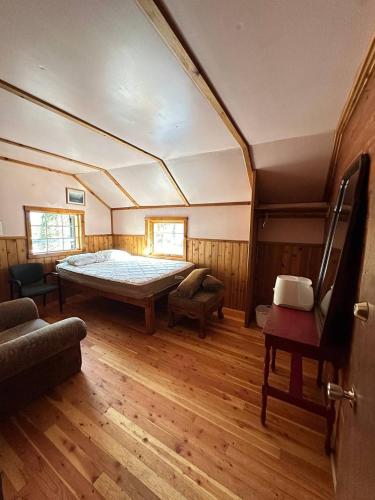 a bedroom with a large bed in a room with wooden floors at Rustic Beaverfoot Lodge Room N10 in Parson