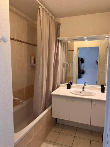 une salle de bain avec un lavabo, une baignoire et un miroir dans l'établissement Studio Le Belvedere 2, à Balaruc-les-Bains