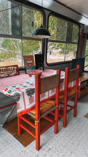 a table and two chairs sitting at a table in a van at Hospedagem Ônibus na Roça em Serra ES in Serra