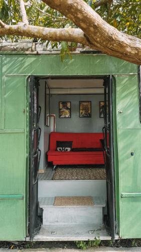 a red couch sitting inside of a tiny house at Hospedagem Ônibus na Roça em Serra ES in Serra