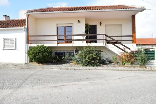a white house with a balcony on a street at Casa na Aldeia in Alburitel