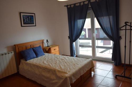 a bedroom with a bed and a sliding glass door at Casa na Aldeia in Alburitel