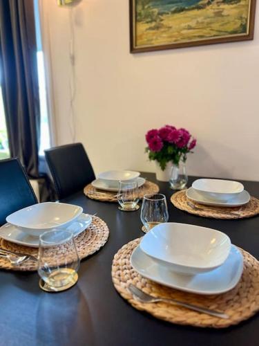 a table with plates and wine glasses on it at Sjönära Villa Lilla Emma, Jädraås, nära Kungsberget in Jädraås