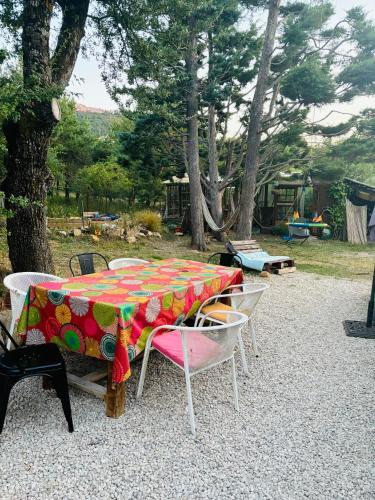 une table et des chaises avec un tissu de table coloré dans l'établissement maison entière foret sainte baume, à Plan dʼAups