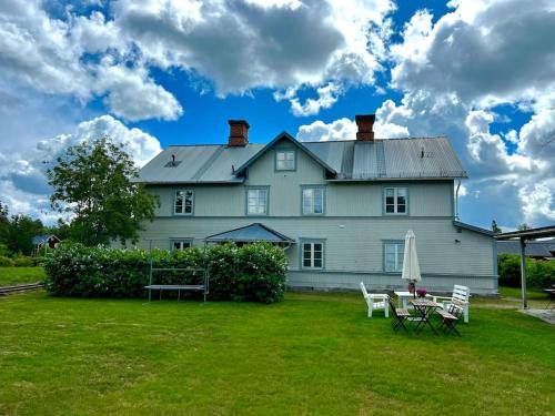 a large white house with a picnic table in the yard at Sjönära Villa Lilla Emma, Jädraås, nära Kungsberget in Jädraås