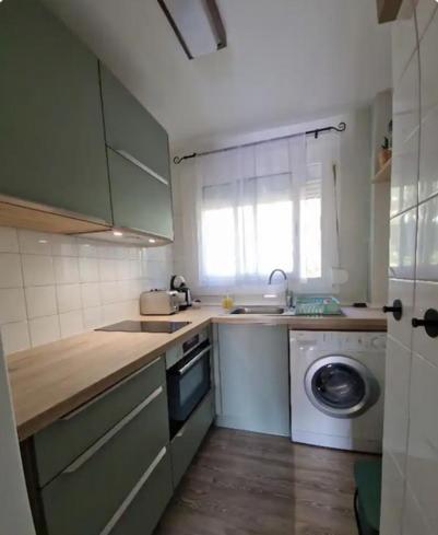 a kitchen with a sink and a washing machine at Appartement tout confort avec WIFI vue sur mer et piscine communautaire secteur EL GOLFET à Callela de Palafrugell in Palafrugell