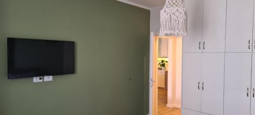 a living room with a flat screen tv on a wall at LA Comfy AP in Sarandë