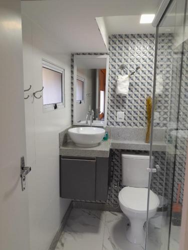 a bathroom with a white toilet and a sink at Apartamento Mania Terceiro Andar in Vitória