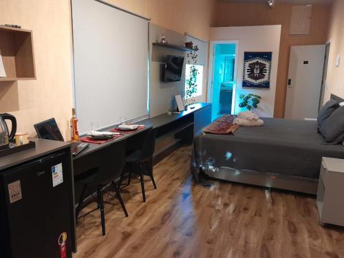 a bedroom with a bed and a desk with chairs at Apartamento Mania Terceiro Andar in Vitória