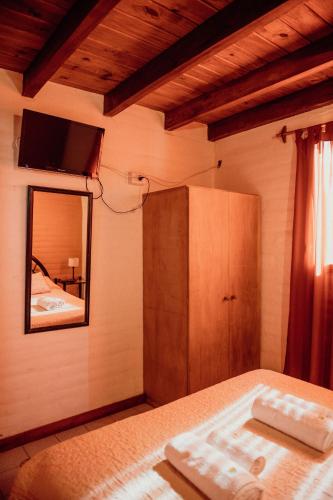 a bedroom with a bed with a mirror and a cabinet at Complejo Cantonavi in Mina Clavero