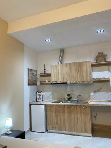 a kitchen with wooden cabinets and a sink at Armando's house Durres in Durrës