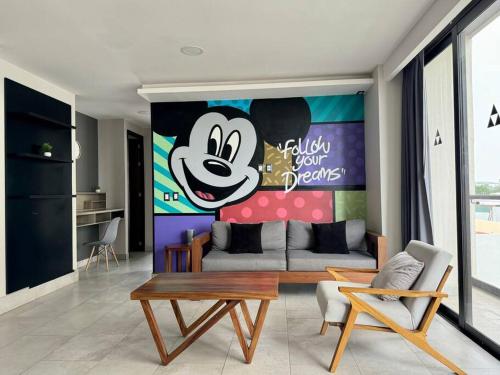 a living room with a mickey mouse painting on the wall at AC Andares Tec Nespresso Estacionamiento Gratis 4p in Guadalajara
