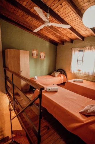 a bedroom with two beds and a ceiling fan at Complejo Cantonavi in Mina Clavero