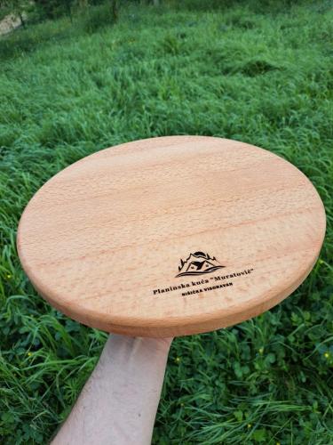 a wooden surfboard sitting on top of the grass at Planinska Kuća Nišićka Visoravan in Sarajevo