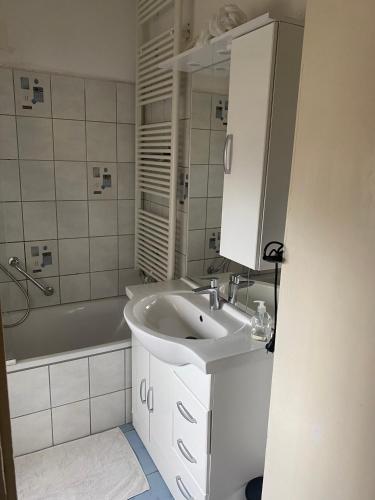 a bathroom with a sink and a bath tub at Palms Zimmer in Frechen