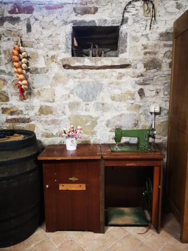 a table with a sewing machine on a stone wall at IL Casale in Giássico