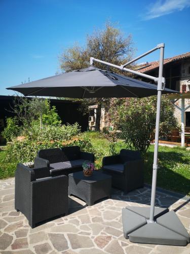 an umbrella and two chairs and a table under it at IL Casale in Giássico