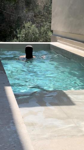 a person swimming in a swimming pool at Palms and Spas Villas Retreat in Mesongi