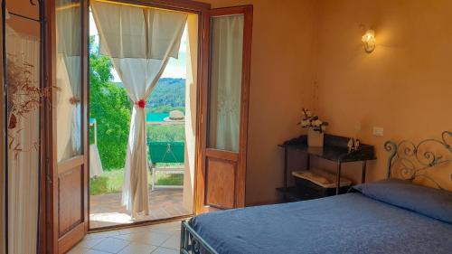 パラーイアにあるAgriturismo Podere le Tombeのベッドとガラスの引き戸のある寝室