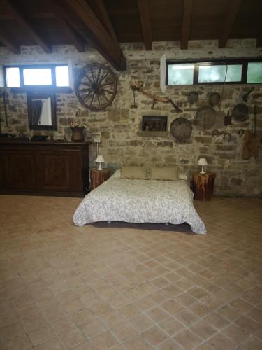 a bedroom with a bed in a stone wall at IL Casale in Giássico
