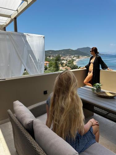 a little girl sitting on a balcony looking out at the ocean at Palms and Spas Villas Retreat in Mesongi