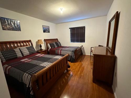 a bedroom with two beds and a desk and a window at Miami VACATION House Cribkeys in Homestead