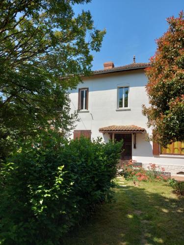 une maison blanche avec une cour et des arbres dans l'établissement La Tuilerie, à Barcelonne-du-Gers
