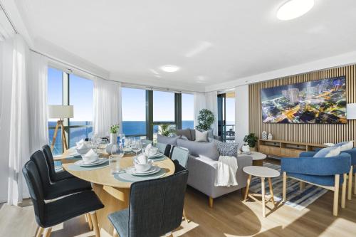a dining room and living room with a table and chairs at Sun City - QStay in Gold Coast