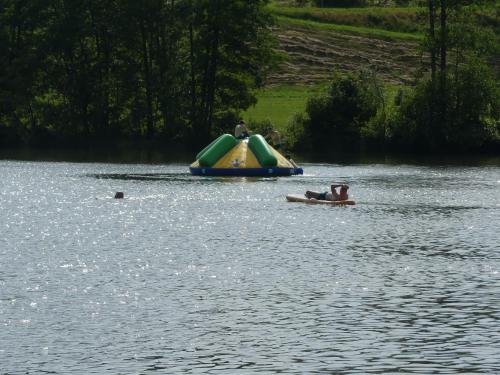 two people in a lake with a slide in the water at Dreiländereck mit Sauna und Pool, Wohnung 403 in Hauzenberg