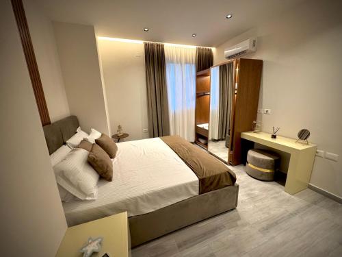 une chambre avec un grand lit et un bureau dans l'établissement Roman Apartments, à Vlorë