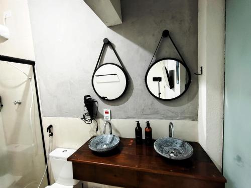 a bathroom with two sinks and two mirrors at Casa Ubatubana I, em Praia do Sapê - Ar condicionado, garagem, cozinha completa e Wi-Fi in Ubatuba