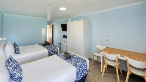 a hotel room with two beds and a table and chairs at Koorawatha Homestead Motel in Bororen