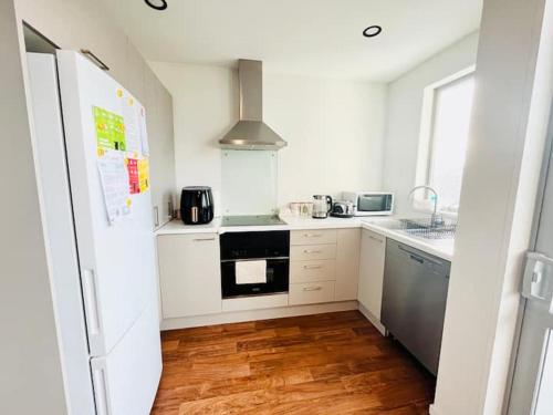 クライストチャーチにあるCity Fringe Private Room - Your Urban Escape!の白い家電製品と木製の床を備えたキッチン
