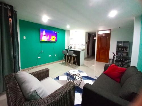 salon z kanapą i zieloną ścianą w obiekcie Apartamento privado y acogedor w Cuzco