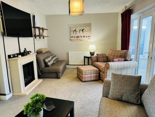 a living room with a couch and a tv at Luxury Jacuzzi Fast WIFI PS5 Gym Parking 2 spaces in Hereford