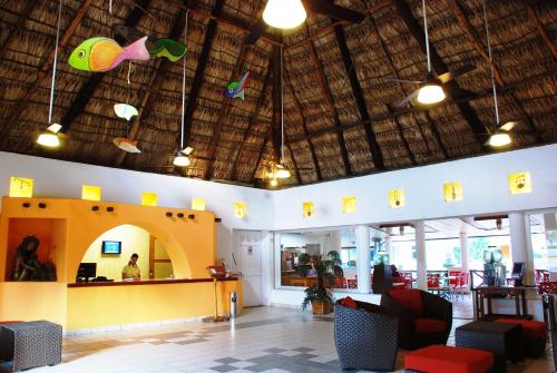 a restaurant with a lobby with a counter and chairs at Hotel Palapa Palace in Tuxtla Gutiérrez