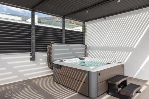 a hot tub on the balcony of a house at Villa AG in Podstrana