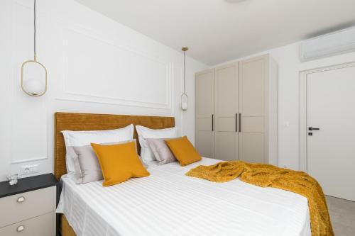 a bedroom with a bed with white and yellow pillows at Villa AG in Podstrana
