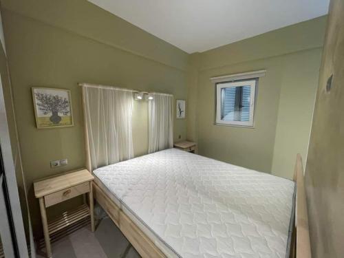 a bedroom with a white bed with a window at Eleni Siviri in Siviri