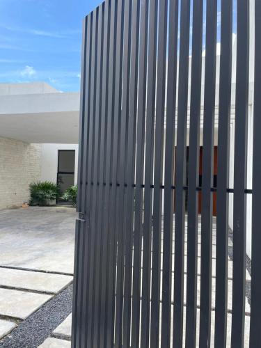 a metal fence on the side of a building at Comodidad y confort en casa Arennas in Mérida