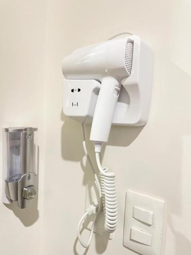 a white phone is attached to a wall at Comodidad y confort en casa Arennas in Mérida