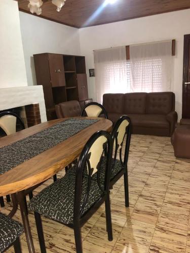 a dining room with a table and chairs and a couch at La Magdalena in Chajarí