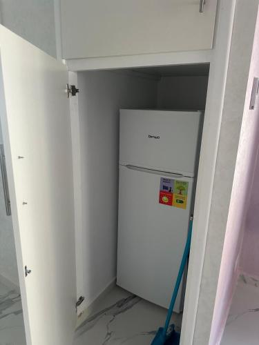 a white refrigerator in a room with a mop at hermoso apartamento con piscina en marjane in Tetouan