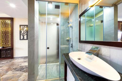 un bagno con lavandino e doccia in vetro di MOJO Boutique HOTEL a Phu Quoc