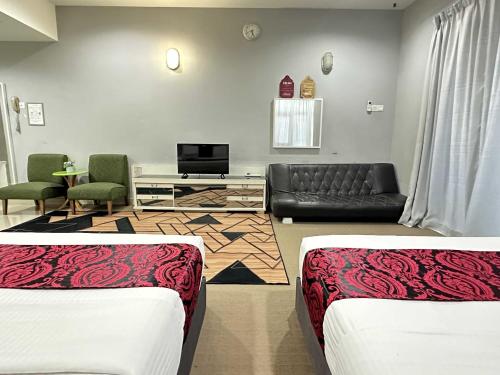 a living room with two beds and a couch at Z&Z Studio Room in Kota Bharu