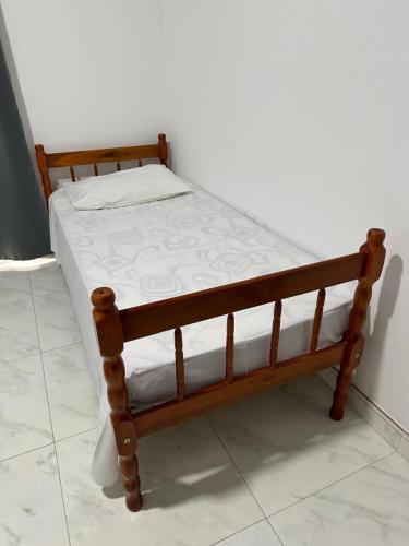 ein Holzbett in einem Zimmer in der Unterkunft Townhouse 03, Beto Carreiro 6Km, Praia Gravata in Navegantes