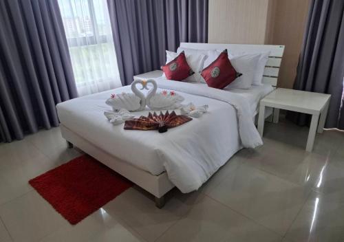 a hotel room with a bed with a tray of food on it at Baan Bangsarey Hotels in Bang Sare